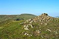 Der Gipfelcairn des südwestlich liegenden Vorgipfels Benyellary, im Hintergrund der Merrick