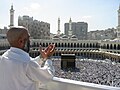 Bedende pilegrim i Masjid Al Haram-moskeen i Mekka med utstyn over Kaba. Foto: 2003