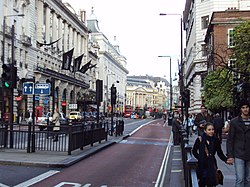Street picture of Piccadilly with bus lane, road signs and the Meriden Hotel. Piccadilly circus is in the background