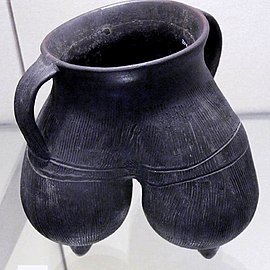 Vase à anses, tripode. Terre cuite grise à lustrage noir, décor excisé. H: 20 cm env. Longshan (sans précision) , 2000-1700[22]. Victoria and Albert Museum