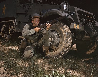 D.R (Demonstraion Regiment: "Gösteri Alayı")'e bağlı bir M3 personel taşıyıcı'nın yanında M1 Garand tüfeğiyle nişan alan ABD Kara Kuvvetleri piyade askeri (Fort Knox, Kentucky, 1942). (Üreten: Alfred T. Palmer)