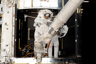 Michael T. Good et Michael J. Massimino réparent l'instrument STIS durant la mission STS-125 (2009).