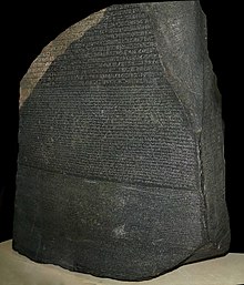 "Velik temno siv kamen z besedilom, ki uporablja stare egiptovske hieroglife, demotsko in grško pisavo v treh ločenih vodoravnih registrih"