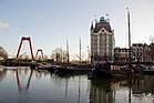 Photographie en couleurs d'un canal longé par des péniches à quais et d'un bâtiment en arrière-plan.