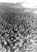 ההמונים מבצעים את ההצדעה הנאצית במהלך עצרת ברובע טמפלהוף-שנברג בברלין במהלך שנת 1935