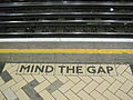 ”Mind the gap”-varoituksilla matkustajia muistutetaan junan ja laiturin välisestä kuilusta. Varoituksia usein myös kuulutetaan.