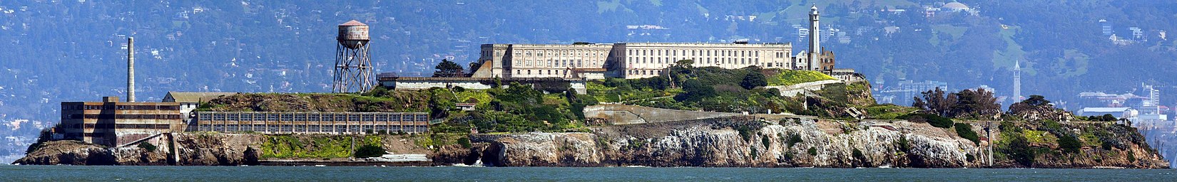 Alcatraz v Sanfranciském zálivu z východu; na pevnině vpravo je zvonice Sather Tower s kampusem Kalifornské univerzity v Berkeley