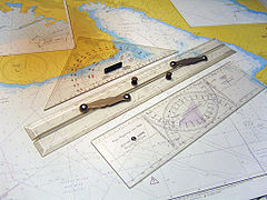 A "Cras navigation plotter" double-protractor, in foreground, named after its inventor Jean Cras.