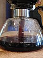 Passo 6: À medida que a jarra de vidro esfria e a água evaporada se contrai, o café moído é puxado através do filtro do recipiente de café moído (por gravidade e diferença de pressão) para dentro da jarra de vidro.