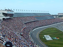 Auto-racing track with a large grandstand filled with spectators