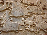 A Persian mid-relief (mezzo-rilievo) from the Qajar era, at Tangeh Savashi in Iran, which might also be described as two stages of low relief. This is a rock relief carved into a cliff.