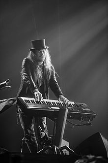 Černobílá fotografie Tuomase Holopainena hrajícího na klávesy v roce 2015.