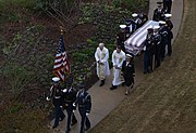 Joint forces honor guard and religious ministers process with the casket to the site of the private family graveside service on December 6, 2018.