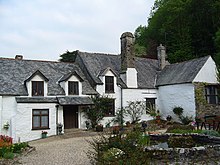 The front of a house with white walls and a gray roof.