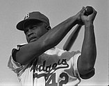 Jackie Robinson swinging a bat in a Dodgers uniform