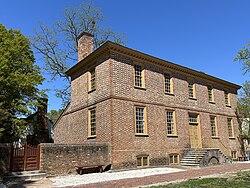 The building's southern front with its one-story rear and westerly wall both visible