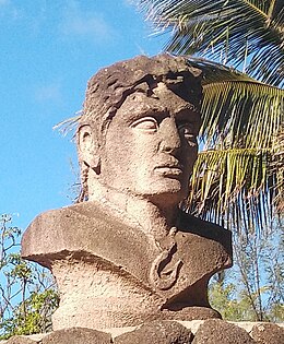 Buste en pierre d'un homme portant un collier avec le symbole de l'île de Pâques en pendentif.