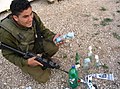 Izraelský voják s materiály na výrobu lahví, které byly nalezeny u dvou palestinských mladíků u checkpointu Huwara