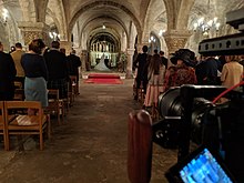 A smaller DLSR camera with a rig shooting a church wedding