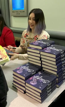 Bowman autographing a book at the American Library Association's Youth Media Awards in 2018