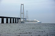 Allure of the Seas passing under the Great Belt Bridge with her funnels lowered.