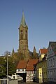 Ortsbild mit Kirchturm und Verlauf der Durchgangsstraße durch ein historisches Fachwerkgebäude