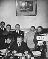 Molotovs paraksta draudzības un robežu demarkācijas līgumu starp Vāciju un Padomju Savienību. Aiz viņa stāv Ribentrops un Staļins