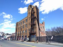 Three-story brick building with four vehicle bays