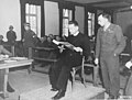 Il sacerdote polacco Theodore Korcz (a sinistra) legge i protocolli sulla malaria in presenza del procuratore capo Denson il 22 novembre 1945.