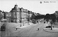 Carte postale en noir et blanc représentant une place sur laquelle circulent des trams et quelques piétons.