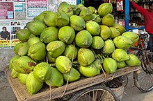 Stack of green coconuts on cart
