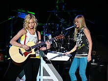 Aly & AJ performing on stage.