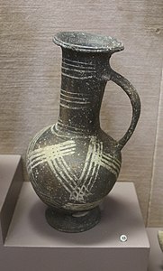 Cruche à décor géométrique peint en blanc sur surface brune, fabrication chypriote (Base ring II). Ras Shamra, Musée d'archéologie nationale.