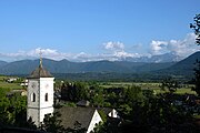 Pfarrkirche Heiliger Kanzian im Nötscher Ortsteil Saak mit Blick auf das Untere Gailtal und die Julischen Alpen im Hintergrund