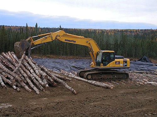 Komatsu PC 220 LC placing logs for a corduroy road