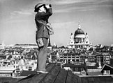 Aircraft spotter on the roof of a building in London. St. Paul's Cathedral is in the background.