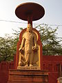 A modern statue of Chandragupta Maurya under a chatra