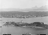 Bodø sett fra Lille Hjartøya Nyholmen i forgrunnen. Nyholmen er et område ytterst på halvøya Burøya kjent for Nyholmen skandse og Nyholmen fyr. Foto: Axel Lindahl (1841–1906) / Nasjonalbiblioteket