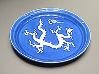 Piatto della dinastia Yuan con il disegno di un drago e di una perla bianchi su uno sfondo blu monocromatico