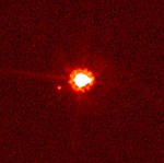 Éris (au centre) et Dysnomie (à gauche) vus par Hubble en 2007.