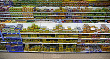 Vue cavalière de plusieurs rayons d’un supermarché bourrés de boîtes de conserve.