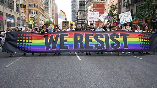 2019 protestors with a variety of signs, the largest being We Resist.