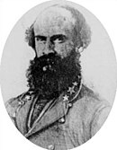 Black and white photo shows a balding man with a heavy beard. He wears a gray uniform with three stars on the collar.