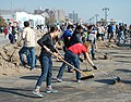 I volontari spazzano il lungomare di Brooklyn dopo l'uragano Sandy del 2012
