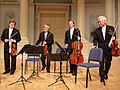 Image 31A modern string quartet. In the 2000s, string quartets from the Classical era are the core of the chamber music literature. From left to right: violin 1, violin 2, cello, viola (from Classical period (music))