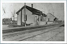A black-and-white postcard of a one-story wooden railway station