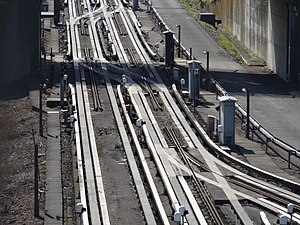 Lille Metro line 1 near Quatre Cantons Workshop, the absence of conventional rail for guidance at junctions is compensated by a central stub guide rail.