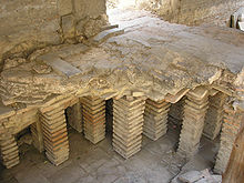 plancher en béton reposant sur des piles de briques