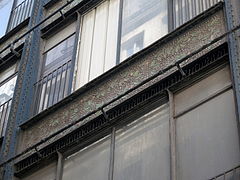 Détail de la façade rue Baillet du magasin 2, décorée avec des grès de Bigot[54].