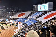 Doğu Asya Futbol Şampiyonası'nın final maçında Tokyo Olimpiyat Stadyumu'ndaki büyük Japonya bayrakları (14 Şubat 2010)
